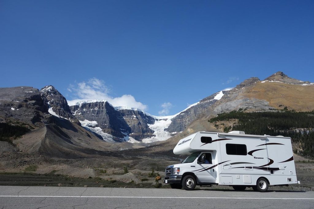 Vrouw kijkt naar berglandschap bij zonsopgang tijdens camperreis door Amerika